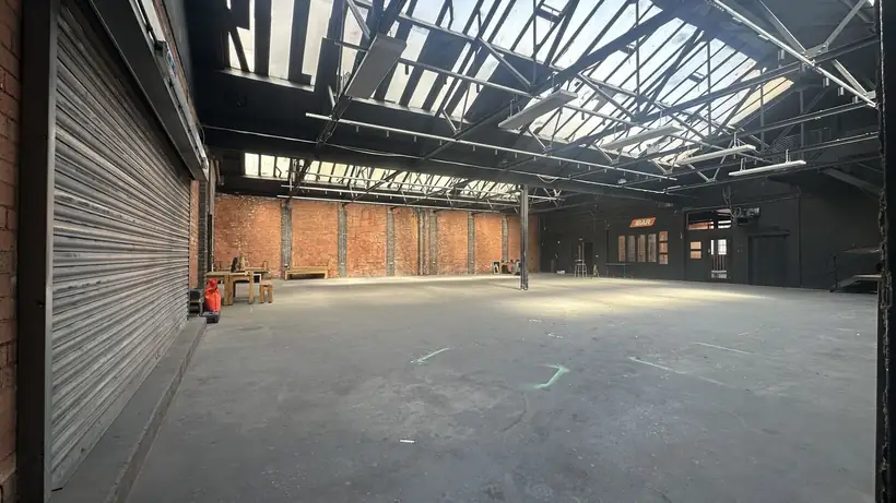 The assembly hall, a long clear span under a saw-tooth roof of skylights